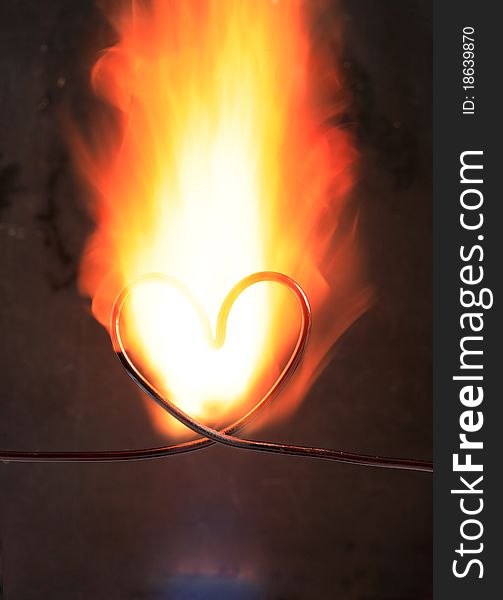 Heart made from wire in fire on dark background. Heart made from wire in fire on dark background