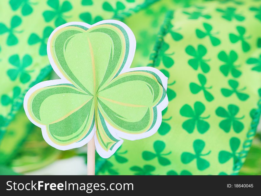 Paper shamrock decoration with shamrock ribbon in the background for St. Patrick's Day. Paper shamrock decoration with shamrock ribbon in the background for St. Patrick's Day