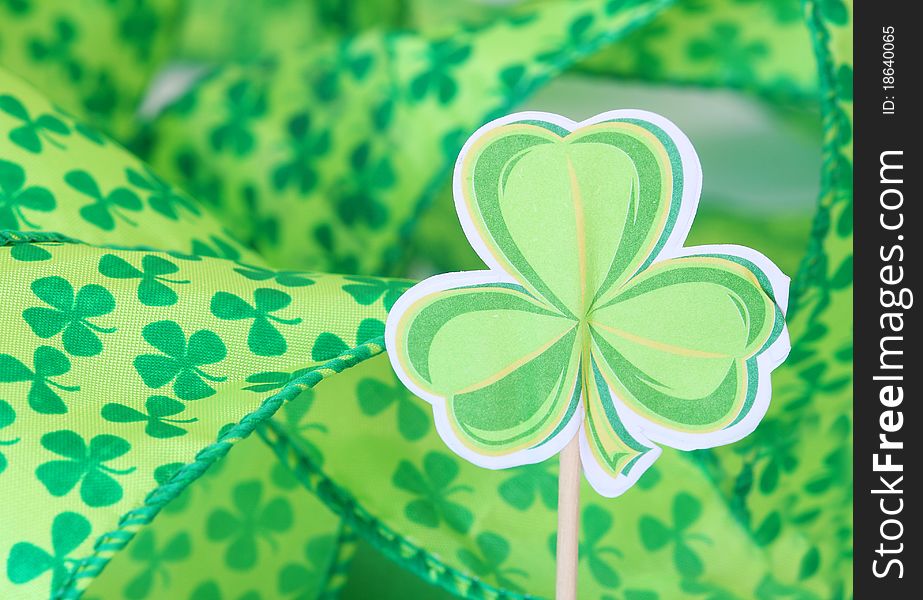 Paper shamrock decoration with shamrock ribbon in the background for St. Patrick's Day. Paper shamrock decoration with shamrock ribbon in the background for St. Patrick's Day