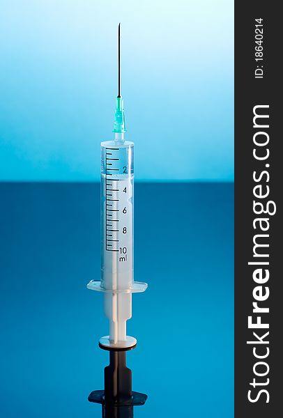 Medical Syringe on dark blue background.