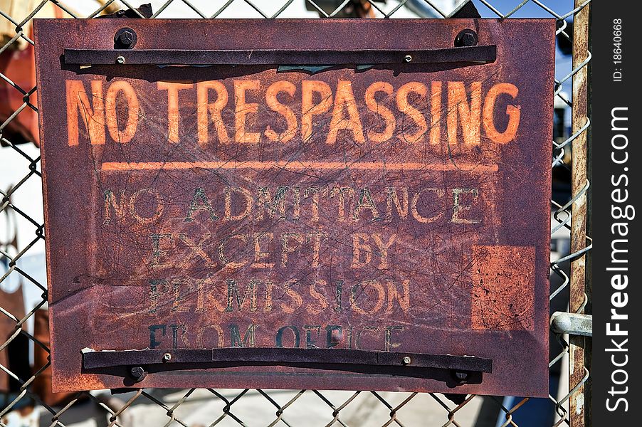 Old No Trespassing sign on a chain link fence. Old No Trespassing sign on a chain link fence