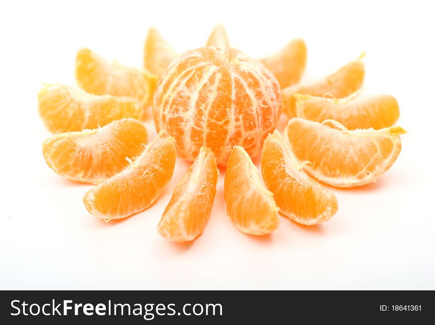 Slices of fresh tangerine with beams isolated on white