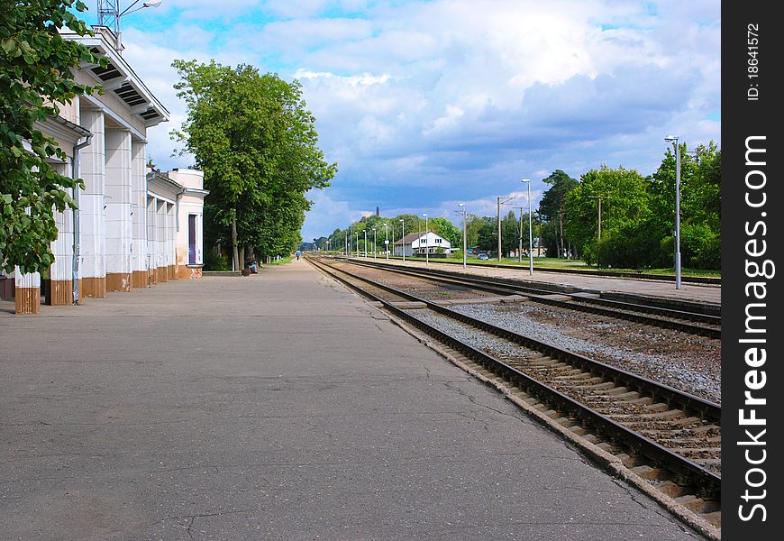The empty track with railway station in Latvia