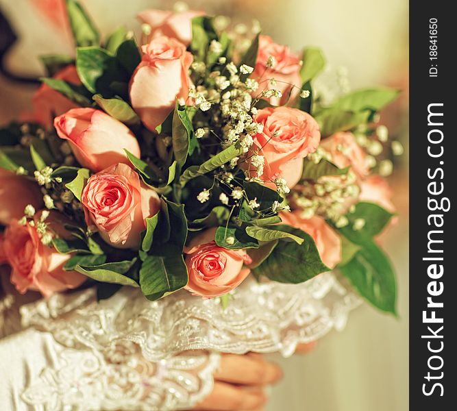 A bride holds her bouquet of pink roses. A bride holds her bouquet of pink roses