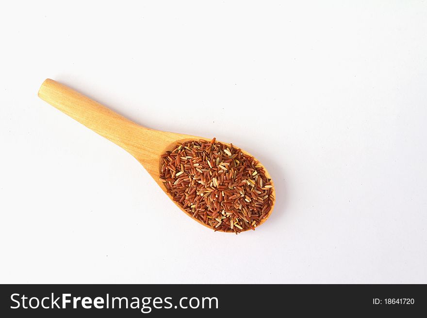 Close-up of a wooden spoon with red rice.