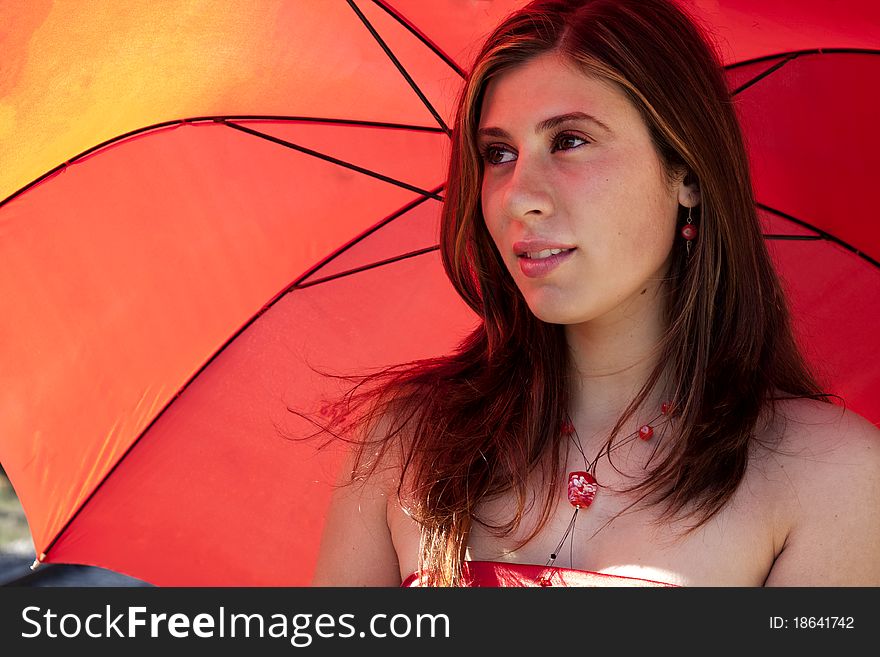 View of a beautiful woman with red dress and umbrella. View of a beautiful woman with red dress and umbrella