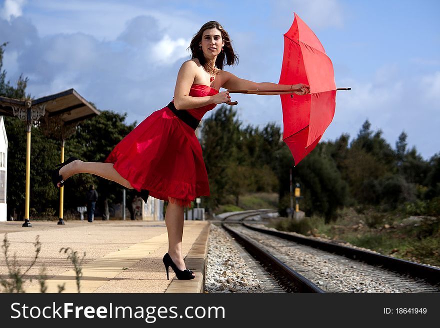 View of a beautiful woman with red dress and umbrella. View of a beautiful woman with red dress and umbrella