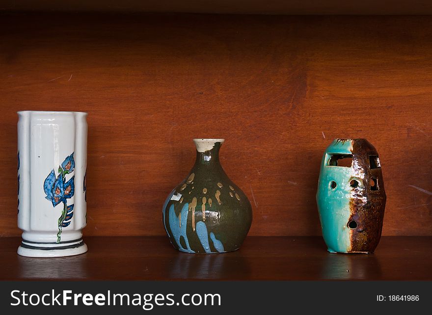 Earthenware on wooden shelf in still-life style