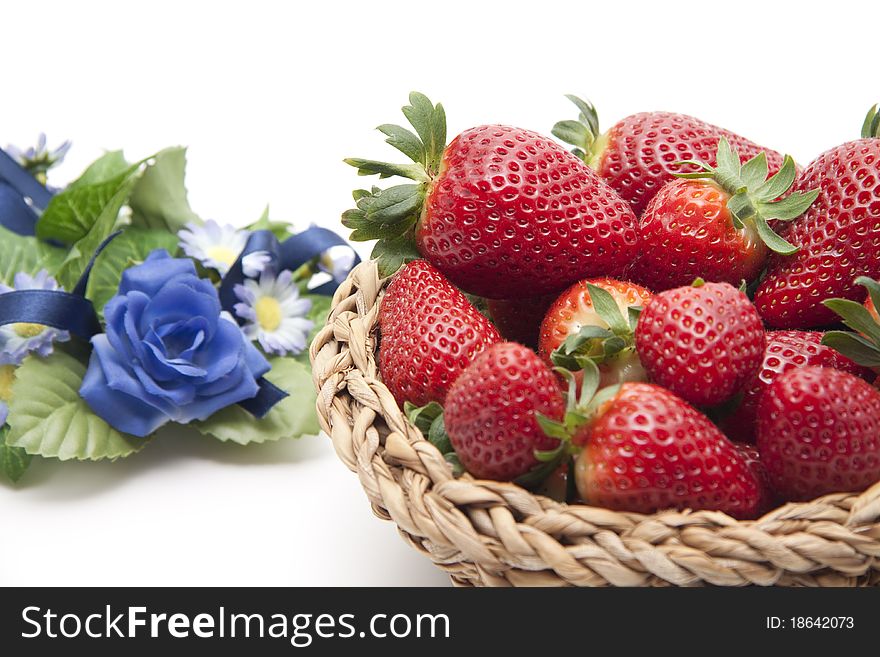 Strawberries in the basket with bunch of flowers