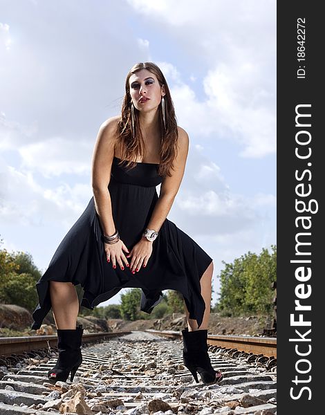 View of a beautiful woman with black dresson a fashion pose.