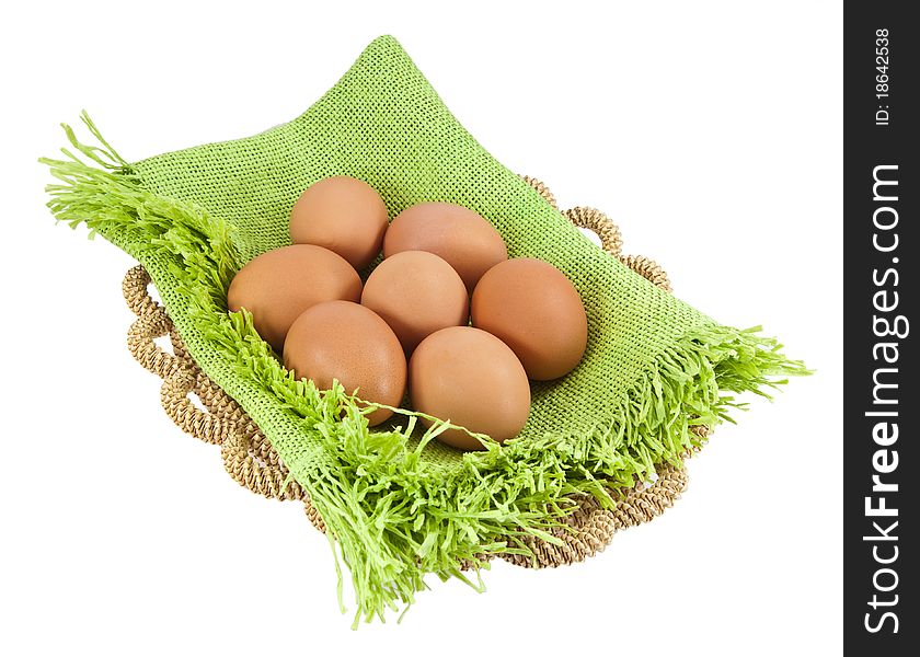 Easter eggs in brown basket on a white background