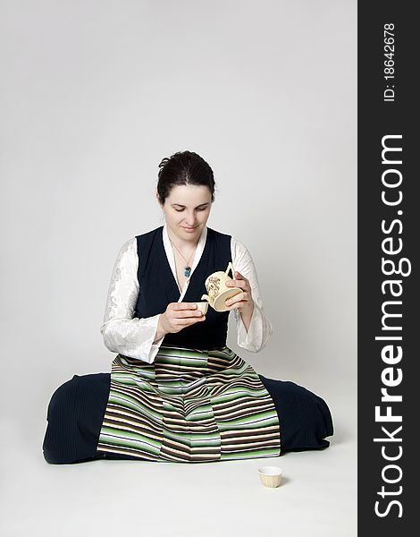 Woman In Traditional Tibetan Dress With Cup Of Tee