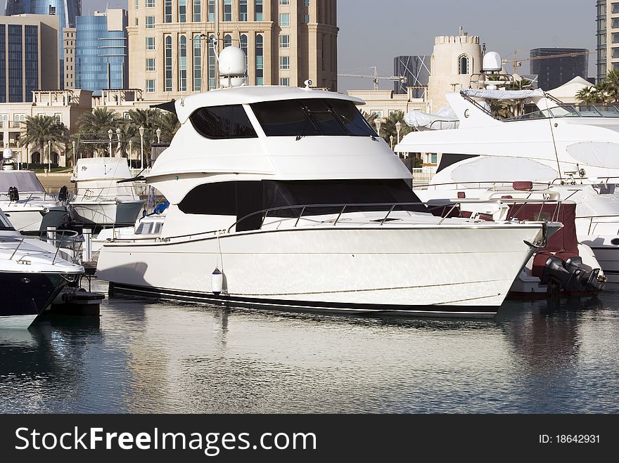 A white boat anchored in a marina