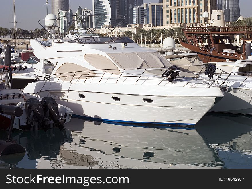 A modern white motor boat anchored in a Yacht club