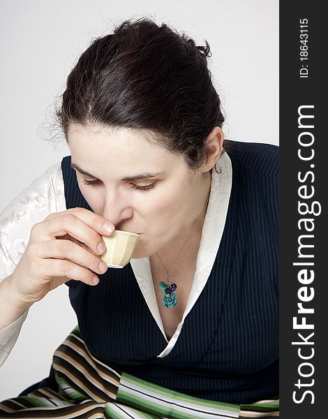 Woman in traditional tibetan dress with cup of tee