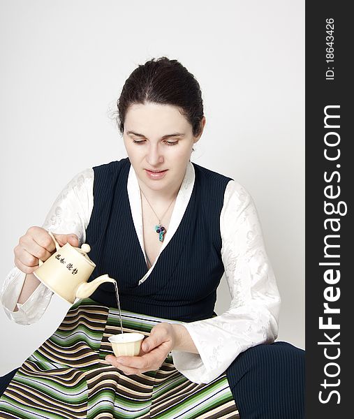 Portrait of woman in traditional tibetan dress with cup of tee