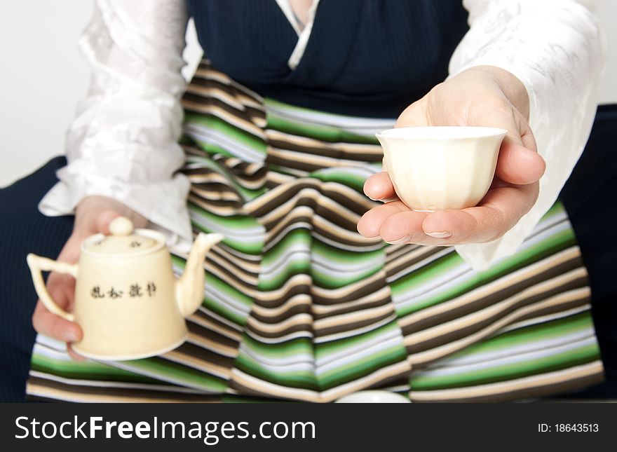 Woman in traditional tibetan dress with cup of tee