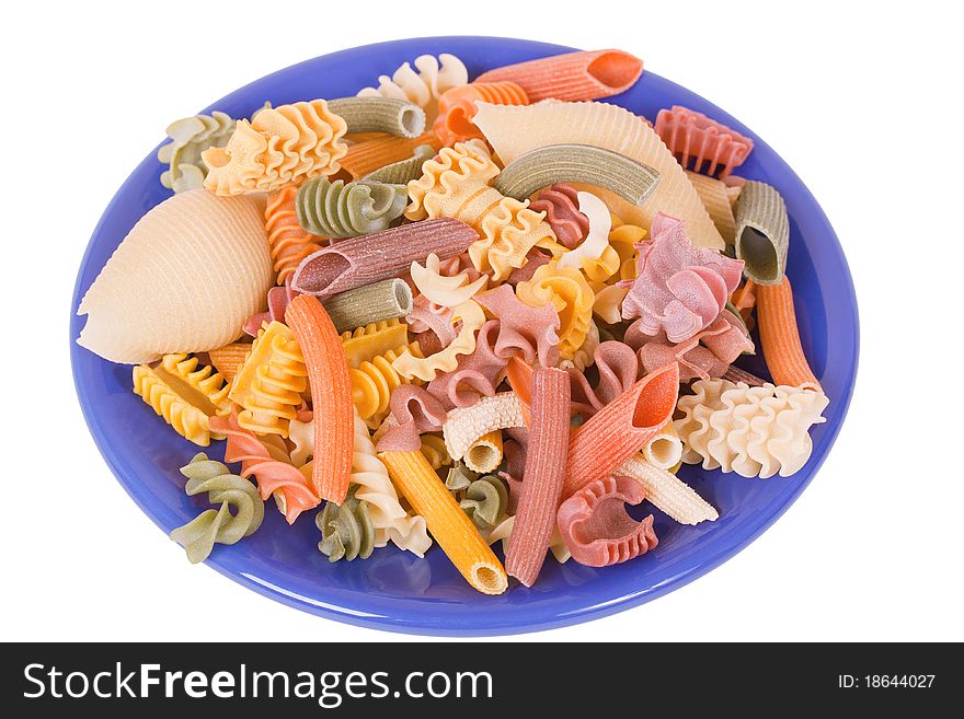 Dry color italien pasta on blue plate isolated over white background