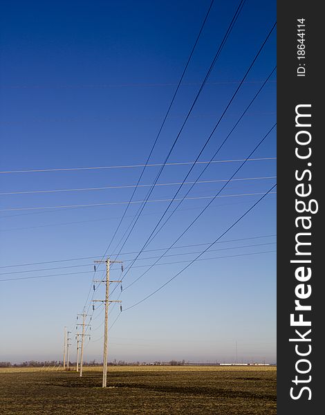 Electrical Power Lines Intersecting with Blue Sky in background