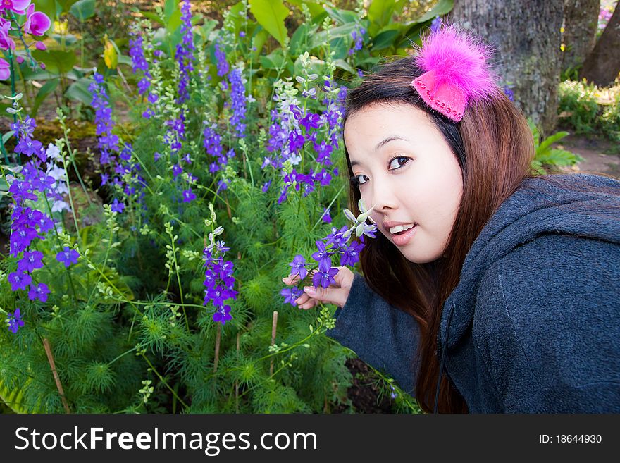 Young woman is smelling some kind of purple flowers. Young woman is smelling some kind of purple flowers