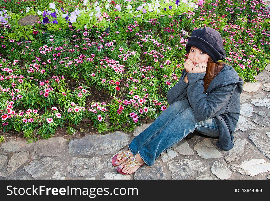 Young woman is resting her chin in hands in dianthus graden. Young woman is resting her chin in hands in dianthus graden