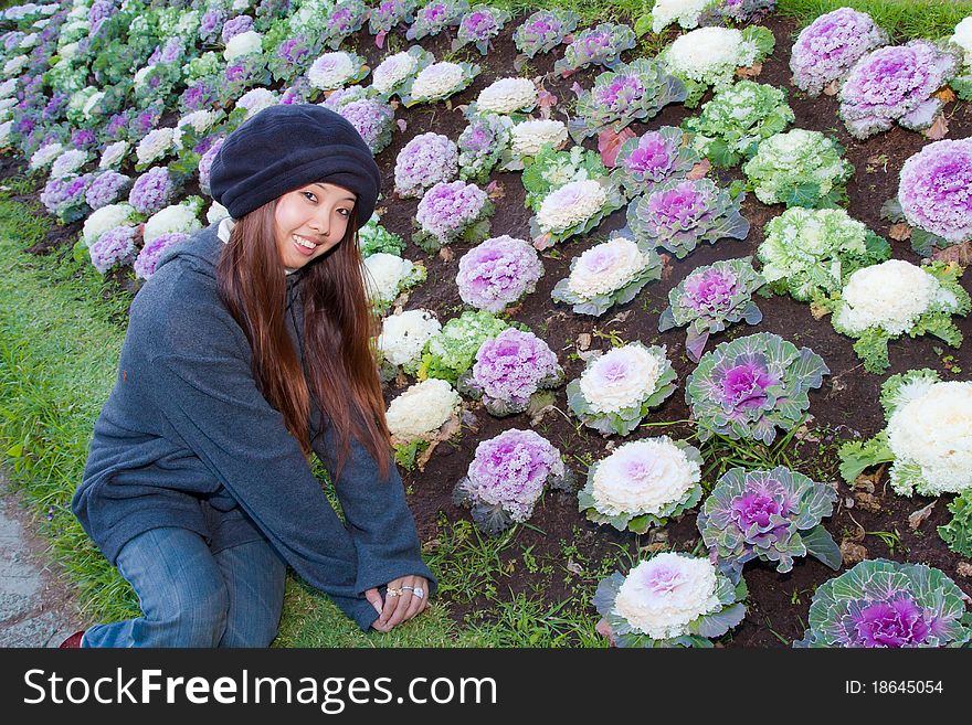 Young woman sitting to Cauliflower garden