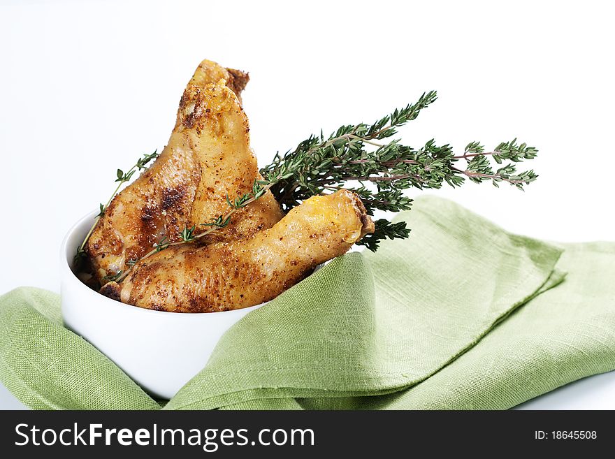 Roasted chicken legs with thyme in a bowl