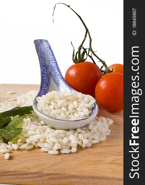 Heap of rice and porcelain spoon with tomato