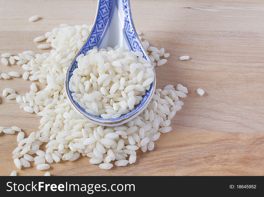 Heap of rice and blue porcelain spoon. Heap of rice and blue porcelain spoon