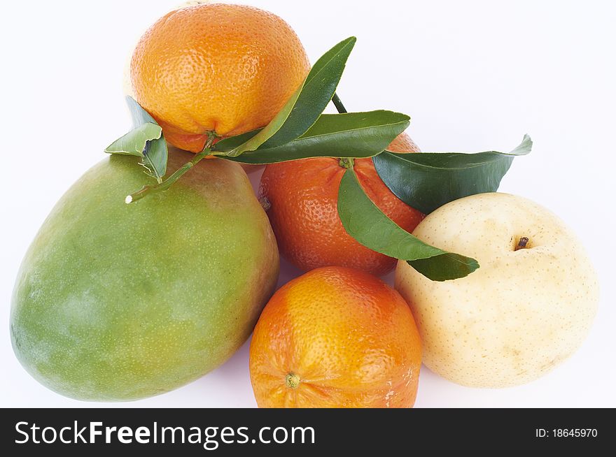 Fresh tangerines, mango and pear with green leafs isolated on white background. Fresh tangerines, mango and pear with green leafs isolated on white background