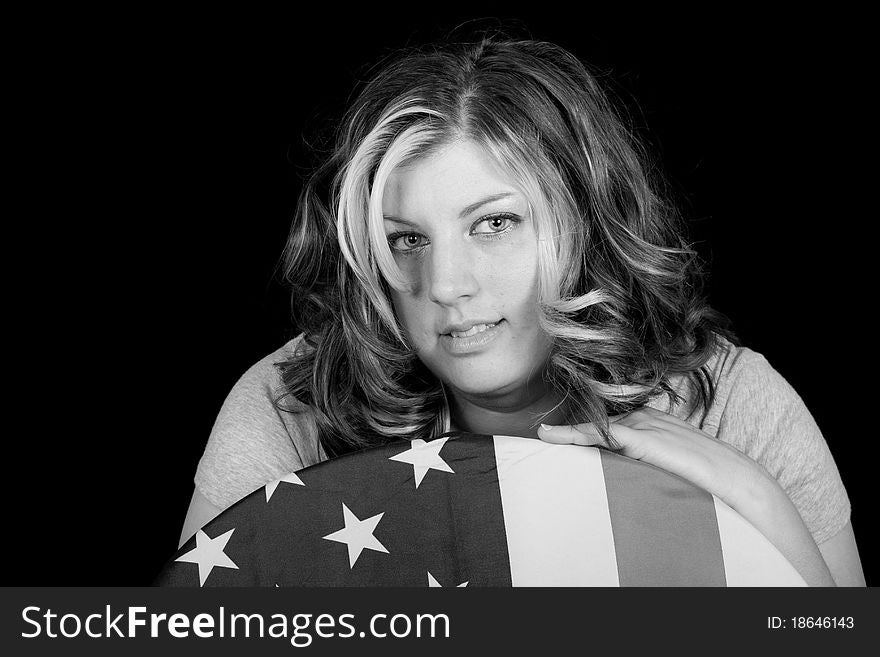 An American Cowgirl sitting on a chair with a flag on it. An American Cowgirl sitting on a chair with a flag on it.