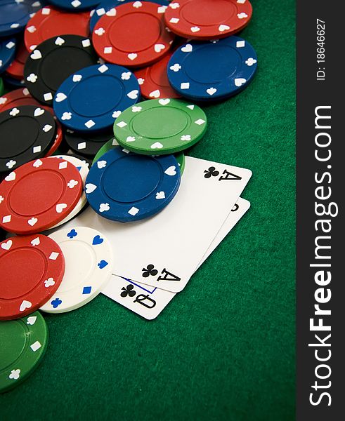 Playing cards and gambling chips on green background