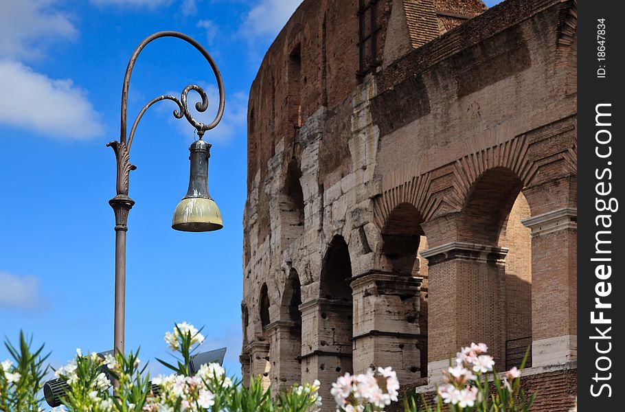 Ornate street lamp with Colosseum in background