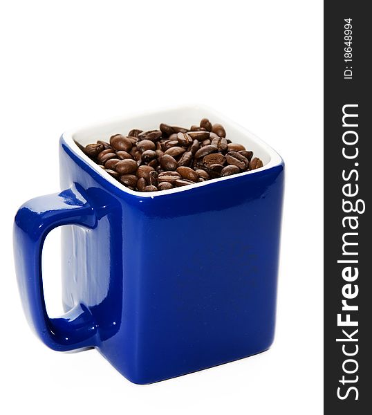 Dark blue cup with coffee grains on a white background. Dark blue cup with coffee grains on a white background