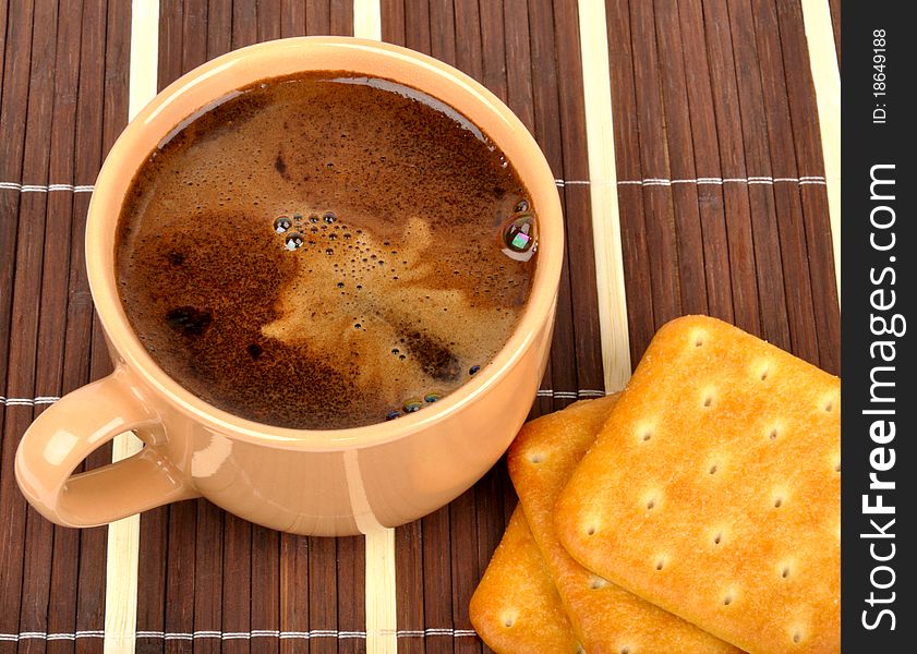 Coffee and crackers on a wooden mat