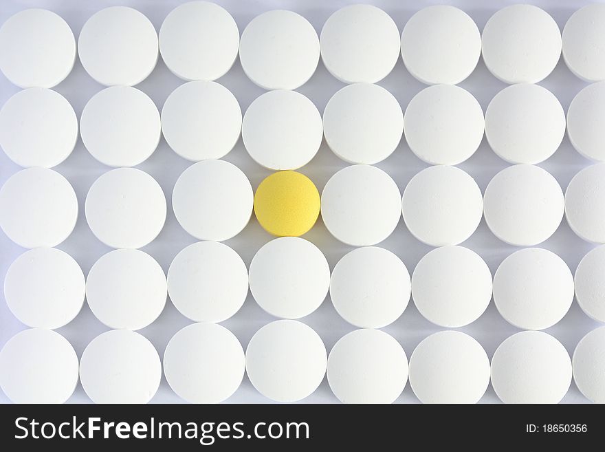 Pattern of white tablets with one that stands out