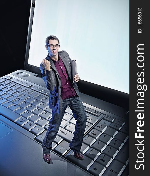 Conceptual photo of a happy man standing on the laptop's keyboard