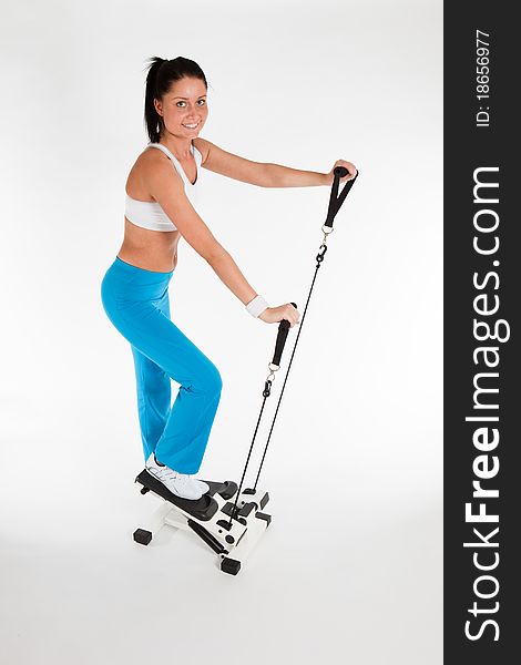 Young woman exercising on stepper trainer, vertical. Young woman exercising on stepper trainer, vertical