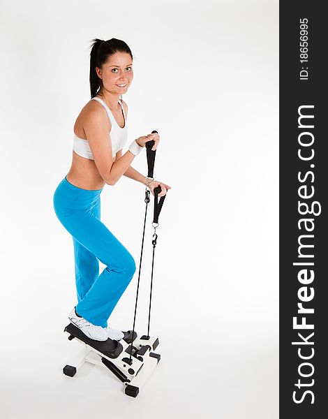 Young woman exercising on stepper trainer, vertical. Young woman exercising on stepper trainer, vertical