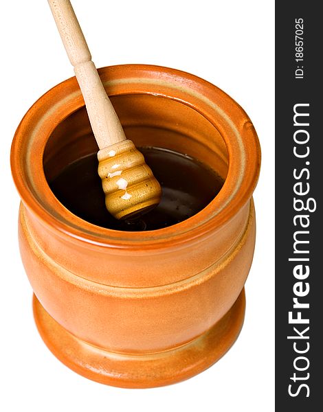 Ceramic jar with honey and wooden stick