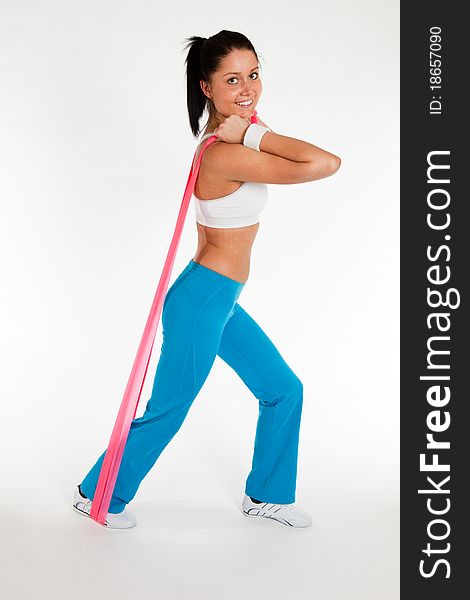 Young woman exercising with rubber ribbon, vertical