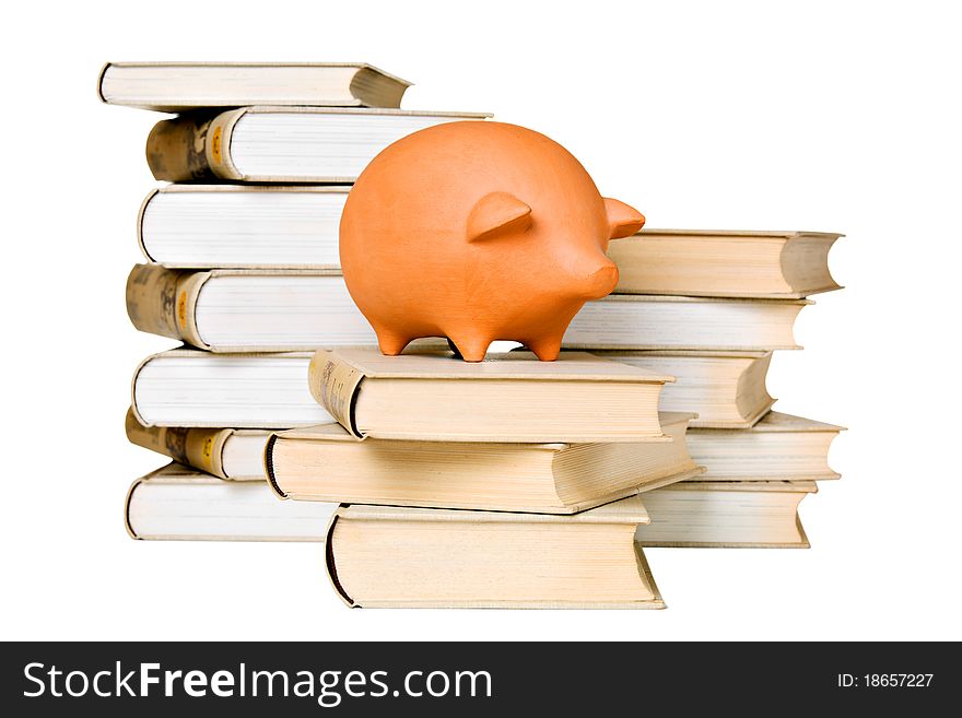 Clay piggy bank and old-fashioned books, isolated on white