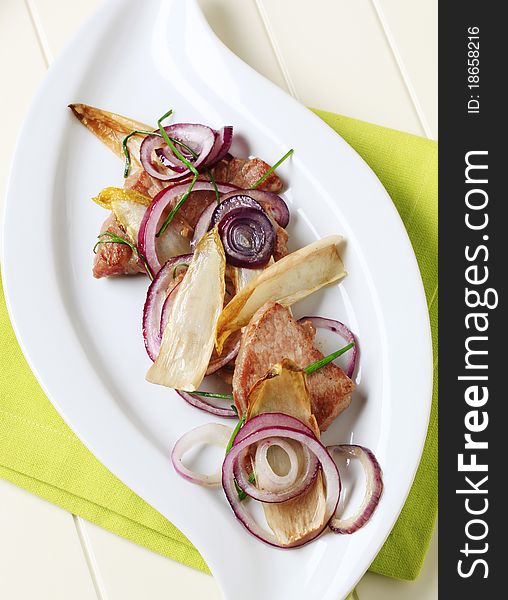 Pan roasted pork with onion and endive leaves. Pan roasted pork with onion and endive leaves