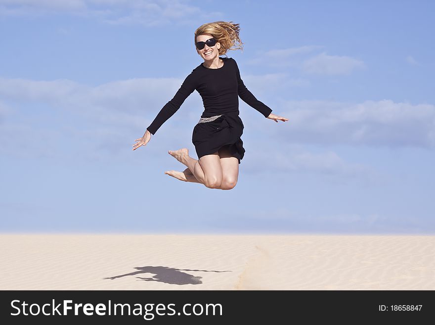Beautifull girl jumping on the sand dune. Beautifull girl jumping on the sand dune.