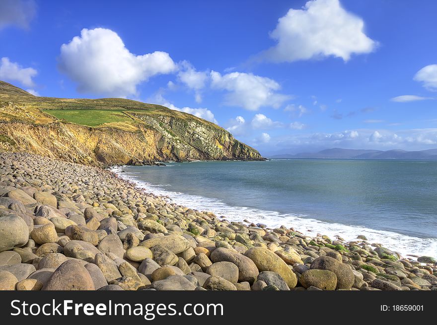 A stone beach with cliffs in background near dingle, Ireland. A stone beach with cliffs in background near dingle, Ireland.