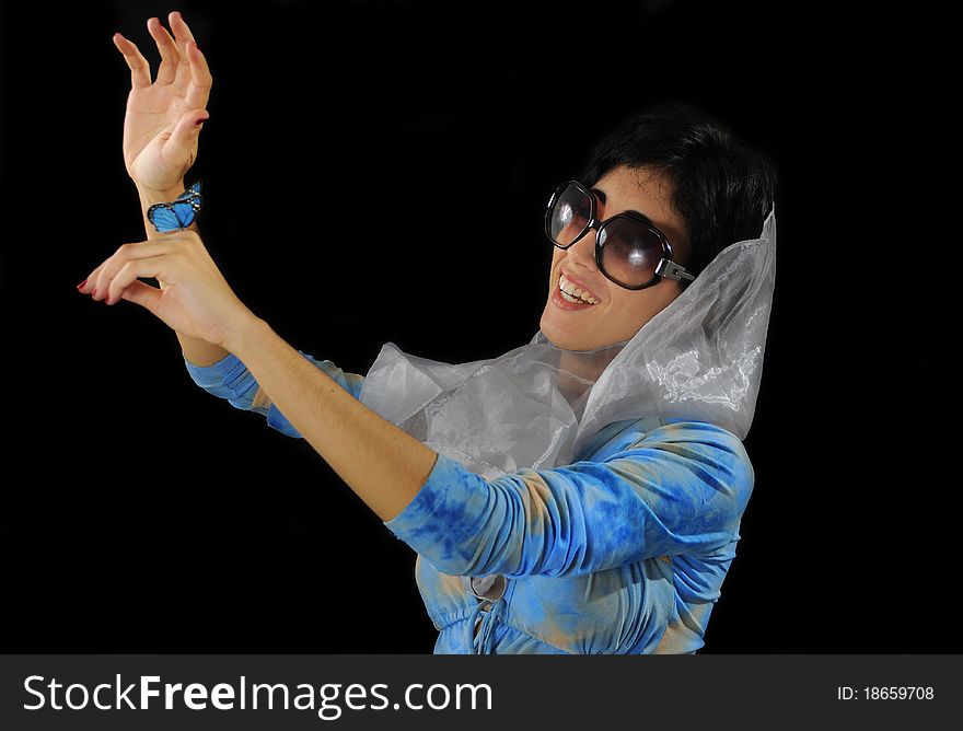 Portrait of young hispanic model wearing sunglasses holding blue butterfly isolated on black. Portrait of young hispanic model wearing sunglasses holding blue butterfly isolated on black