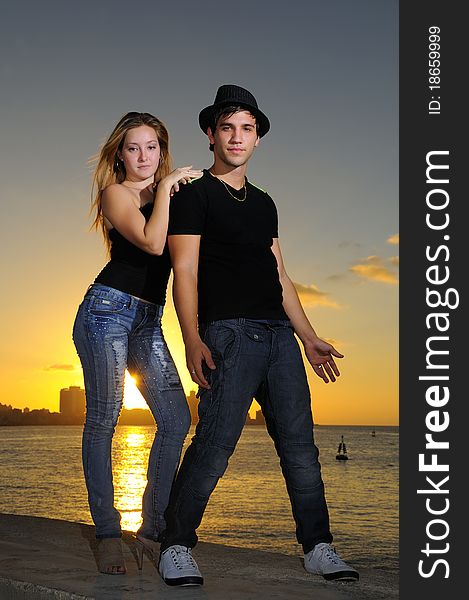 Cool young couple standing at sunset