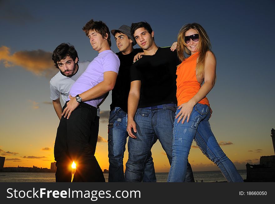 Portrait of young hispanic trendy team posing outdoors at sunset. Portrait of young hispanic trendy team posing outdoors at sunset