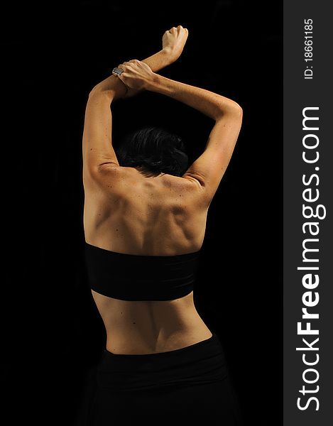 Abstract female back with black top isolated on black background. Abstract female back with black top isolated on black background