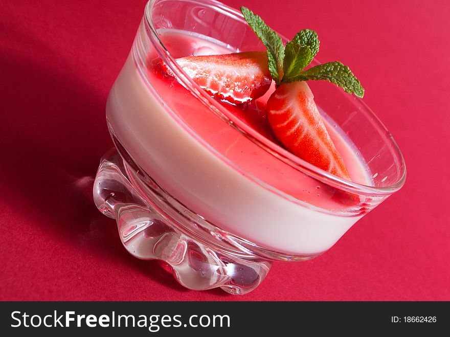 Italian dessert panna cotta on white plate decorated with strawbery, mint and fruit syrup. Italian dessert panna cotta on white plate decorated with strawbery, mint and fruit syrup